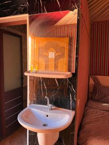 a bathroom with a sink and a bed at Omar wadi rum camp in Wadi Rum