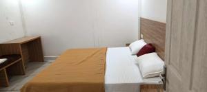 a bedroom with a bed with white sheets and red pillows at Heavenly monsoon villa in Devikolam +4 photos