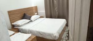 a bedroom with a bed with white sheets and pillows at Heavenly monsoon villa in Devikolam