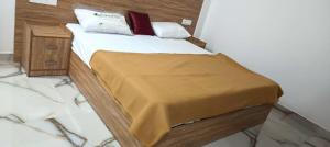 a bedroom with a bed with a yellow blanket on it at Heavenly monsoon villa in Devikolam