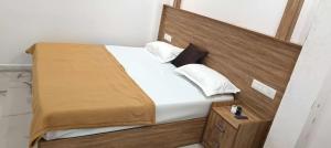 a bedroom with a bed with a wooden headboard at Heavenly monsoon villa in Devikolam