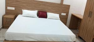 a bedroom with a white bed with two red pillows at Heavenly monsoon villa in Devikolam