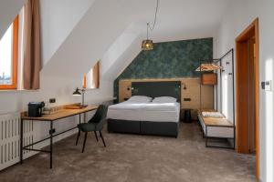 a bedroom with a bed and a desk and a chair at Hotel Slovan in Jeseník