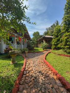 a cobblestone path in front of a house at Rimzim's Tatvamasi - A Pool Villa Retreat in Kudāl
