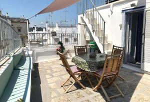 a patio with a table and chairs on a balcony at Casa Zefiro by Rentbeat in Ostuni
