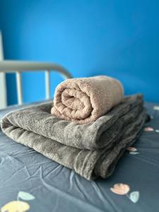 a pile of towels sitting on top of a bed at Podium 3BR 2BH Modern Homestay Near Aeon in Kuching