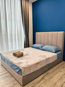 a bedroom with a large bed with a blue wall at Podium 3BR 2BH Modern Homestay Near Aeon in Kuching +36 photos