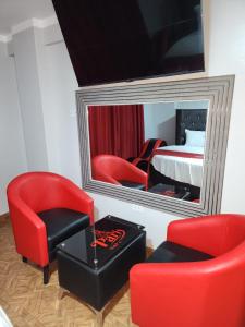 a room with a red chair and a mirror at Hostal Paris MYP 3 in Lima +26 photos