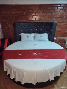 a large bed with a red and white blanket at Hostal Paris MYP 3 in Lima