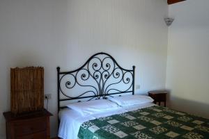 a bedroom with a bed with a green and white quilt at Stazzu Spadulagliu near Olbia in Telti