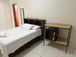 a bedroom with a bed and a table with a television at Suite Campina - Business Hotel in Campina do Monte Alegre +7 photos