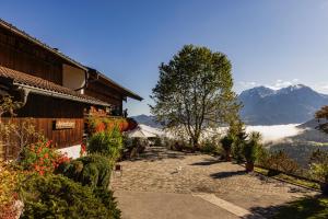 ein Weg, der zu einem Haus mit Bergen im Hintergrund führt in der Unterkunft Ferienwohnungen Gerstreitlehen in Ramsau bei Berchtesgaden