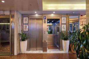 an elevator in a building with potted plants at Hotel Ronda Lesseps in Barcelona