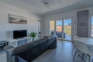 a living room with a black leather couch and a table at Casa Dalia in Garbagnate Milanese