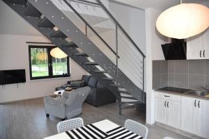 a kitchen and living room with a spiral staircase at Lubiatówki in Lubiatowo