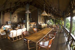 une salle à manger avec une grande table et des chaises en bois dans l'établissement Lumbalumba Resort - Manado, à Manado