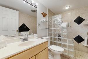 a bathroom with a toilet and a sink and a shower at Island Sands Resort 103 in Maalaea +20 photos
