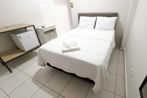 a small bedroom with a bed with white sheets at Suite Campina - Business Hotel in Campina do Monte Alegre