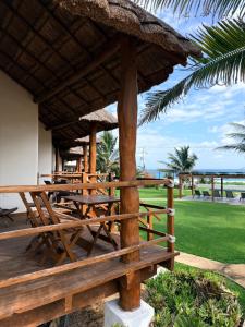 un ponte di legno con tavoli e un ombrellone di paglia di Villa with ocean view, pool, restaurant and rooftop a Isla Mujeres