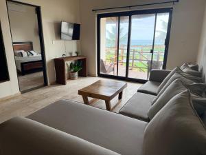 un soggiorno con un divano e un tavolo di Villa with ocean view, pool, restaurant and rooftop a Isla Mujeres