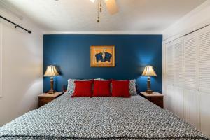 een blauwe slaapkamer met een bed met rode kussens bij Chetola: Holly 4 in Blowing Rock
