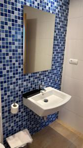 ein Badezimmer mit einem weißen Waschbecken und einem Spiegel in der Unterkunft Duplex in Bocairent