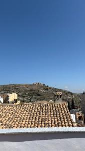 Ein Gebäude mit Ziegeldach vor einem Hügel im Hintergrund in der Unterkunft Duplex in Bocairent