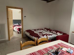 a room with two beds and a table and a mirror at Casa di Ada in Segonzano