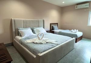 um quarto com 2 camas e toalhas brancas em Excel Hotel Bangkok former Sri Krungthep Hotel em Banguecoque