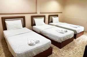três camas num quarto de hotel com toalhas em Excel Hotel Bangkok former Sri Krungthep Hotel em Banguecoque