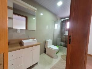 a bathroom with a toilet and a sink and a shower at Casa vista das colinas in Gramado