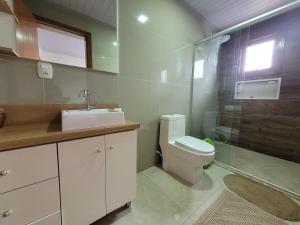 a bathroom with a toilet and a sink and a shower at Casa vista das colinas in Gramado