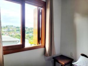 a window in a room with a table next to it at Casa vista das colinas in Gramado