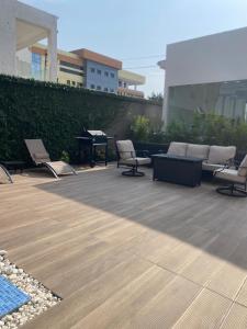 a patio with lounge chairs and a piano on a building at Executive studio at East Legon in Accra