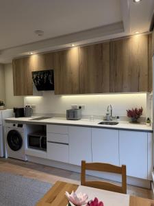 eine Küche mit weißen Schränken und einer Spüle in der Unterkunft KAStay london in London
