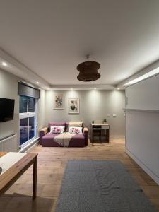 ein Wohnzimmer mit einem lila Sofa und einem Tisch in der Unterkunft KAStay london in London