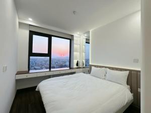 An KhêTera Apartment Hoàng Huy Commerce的卧室里有一张白色的大床和两扇窗户