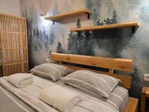 a large bed in a bedroom with a mural at Artizan Chalet in Topliţa