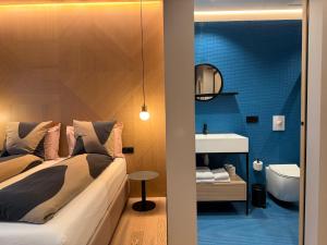 a bedroom with a bed and a bathroom with a sink at Hotel Lotus in Reykjavík