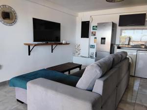 Caribbean Sunset, Malendure, Vue Mer, Jacuzzi Privé في بويانت: غرفة معيشة مع أريكة وتلفزيون بشاشة مسطحة
