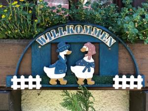 un cartello di legno con due pinguini sopra di Große Ferienwohnung Oberzarten a Hinterzarten