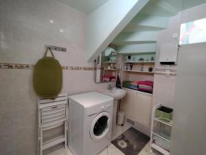 RiaAppartement à Ria-sirach的配有洗衣机和水槽的浴室