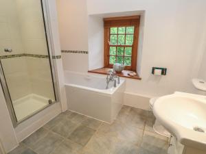een badkamer met een bad, een douche en een wastafel bij 1 Rowes Cottages in Porthcurno +32 foto's