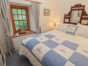 een slaapkamer met een bed en een raam bij 1 Rowes Cottages in Porthcurno