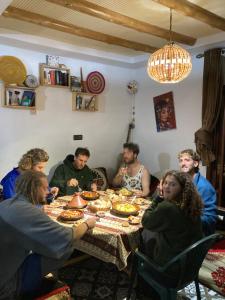 a group of people sitting around a table eating at Boilers Surf House in Tamri
