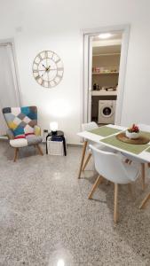 格拉维纳普利亚B&B Sotto l'Arco的客厅配有桌椅和时钟