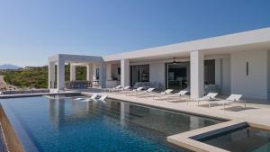 a villa with a swimming pool and lounge chairs at Poco Paraiso in San José del Cabo