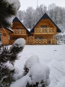 a large wooden cabin with snow on the ground at Domek Luna Wilcza Zagroda in Kudowa-Zdrój +19 photos