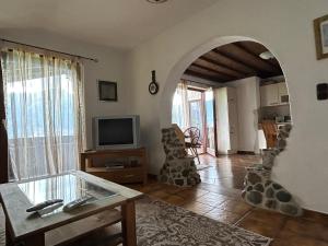 Una sala de estar con una mesa y un televisor. en Maem`s Adlerhorst, en Irschen