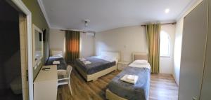 TepelenëにあるVealのベッド2台と机があるホテルの部屋